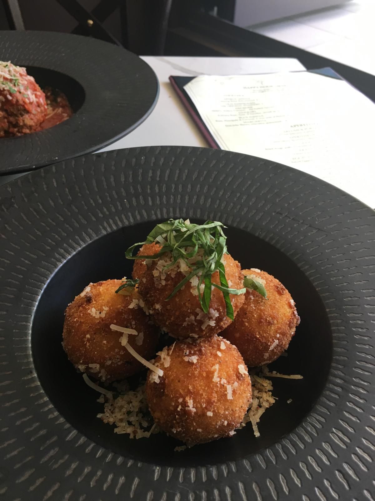 Golden fried arancini rice balls dusted with Parmigiano and fresh herbs